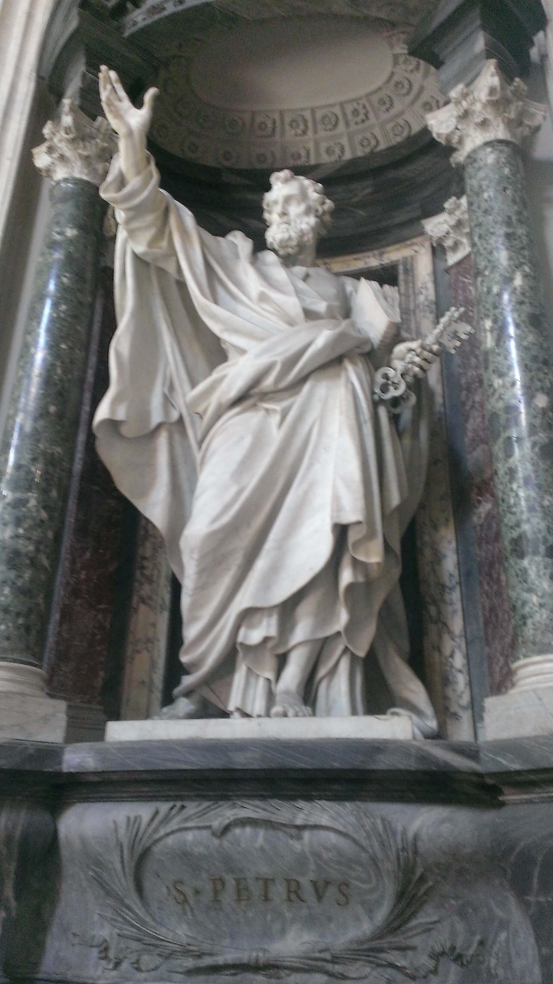 Petrus streckt seine rechte Hand aus und hält unterm linken Arm die Heilige Schrift und in der linken Hand einen Schlüssel.