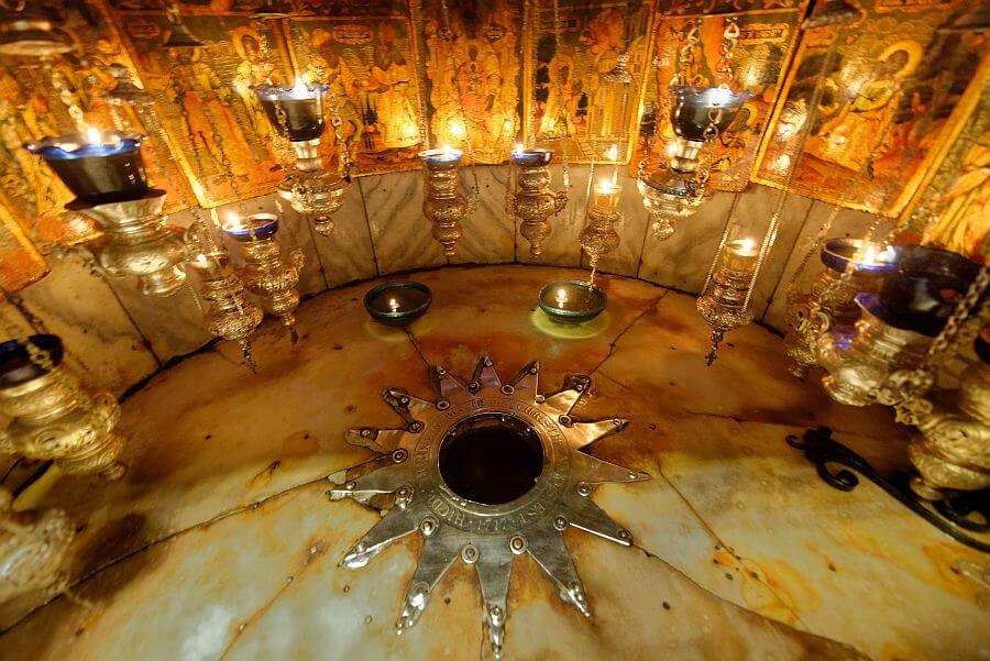 Wir blicken auf den Geburtsort Jesu. Er ist zu einem Altar mit vielen Öllampen gestaltet.